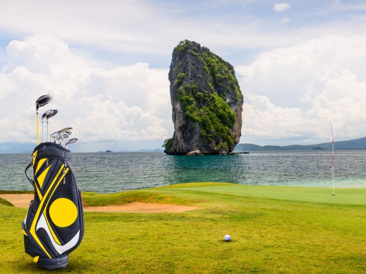 Golf course with a limestone island in the sea near Krabi, Thailand